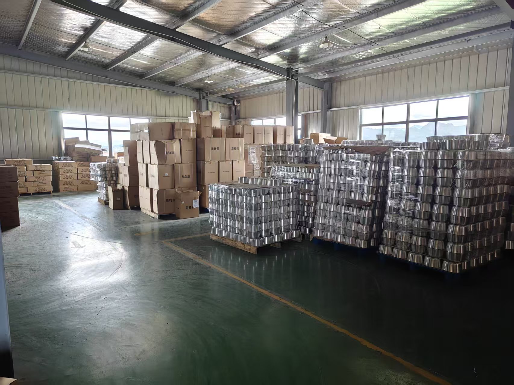 Cookware warehouse with finished metal products and cartons on pallets