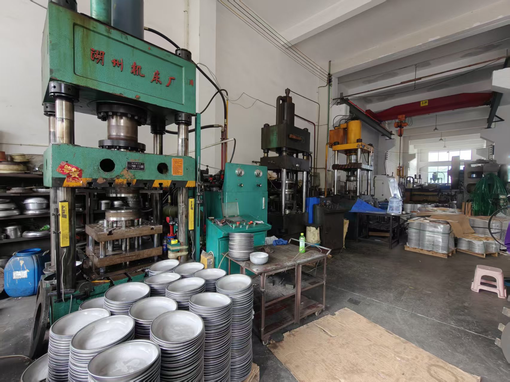 Cookware forming workshop with hydraulic presses and unfinished frying pan bodies