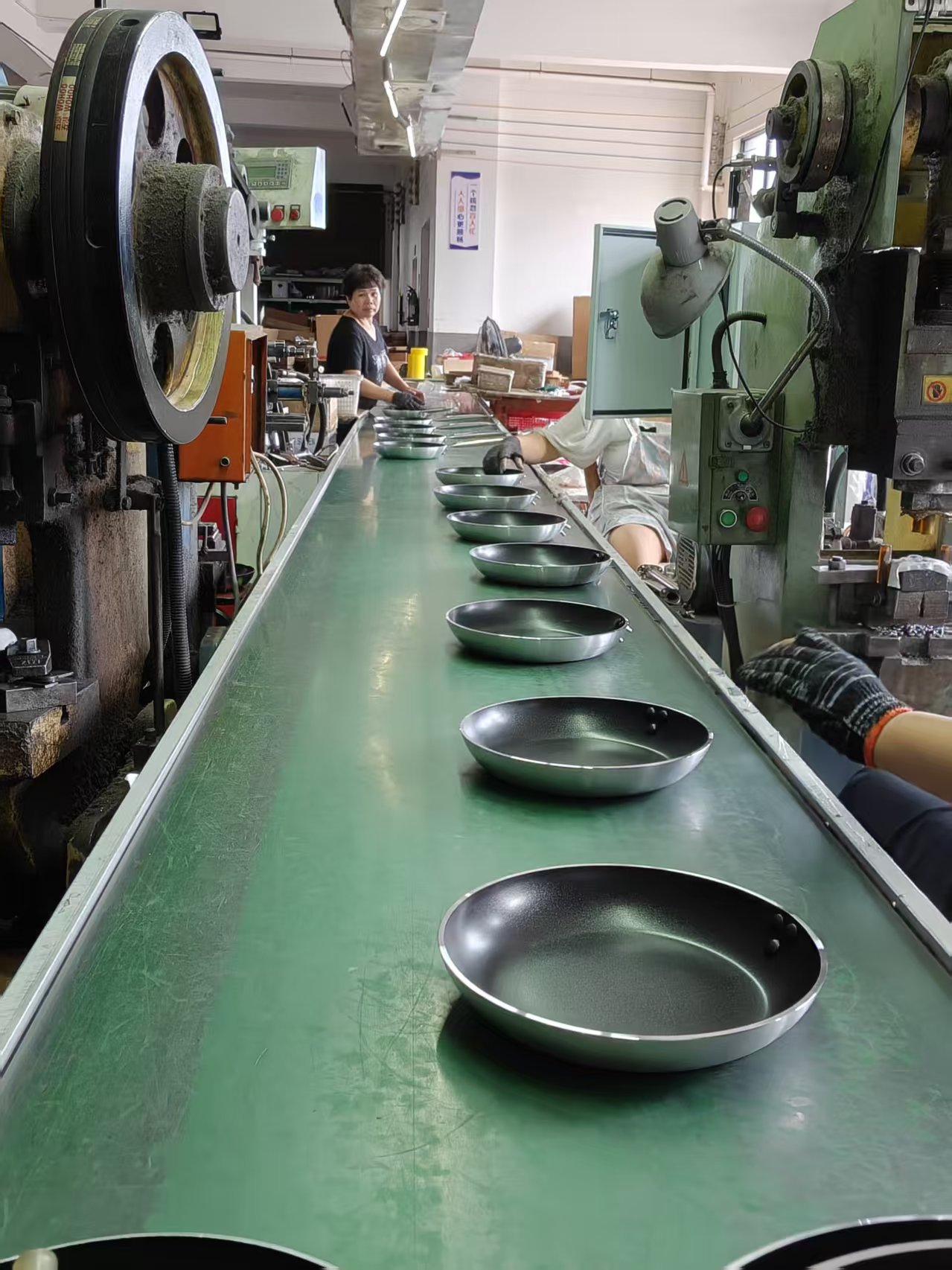 Frying pan bodies moving through an in-process production line